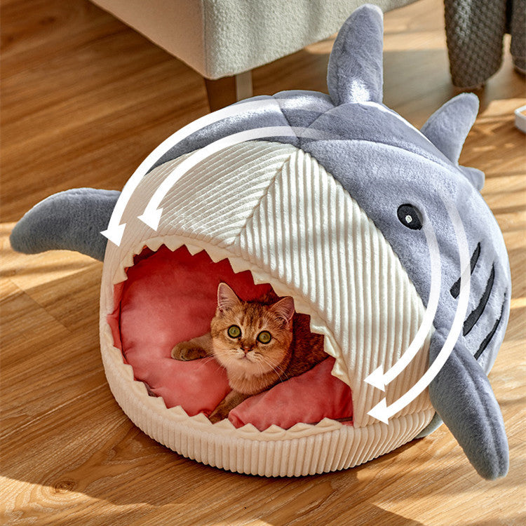 A display image of a pet sitting inside the Snugglebugsupply's Shark-Shaped Pet House Bed