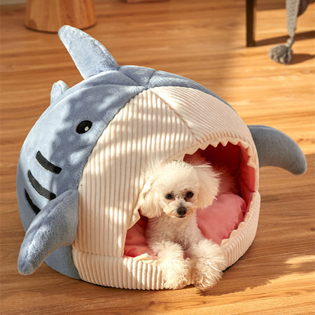 A display image of a pet sitting inside the Snugglebugsupply's Shark-Shaped Pet House Bed