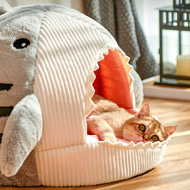 A display image of a pet sitting inside the Snugglebugsupply's Shark-Shaped Pet House Bed